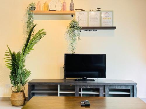a living room with a television on a table at Desaru Beach Luxury Suite Pool View C1 in Bandar Penawar