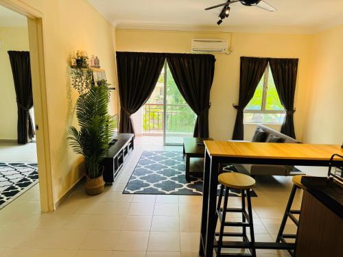 a living room with a table and chairs and a plant at Desaru Beach Luxury Suite Pool View C1 in Bandar Penawar