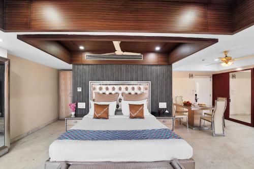 a bedroom with a large bed and a table at Palette Orient Hotel & Convention Centre by CheckIn, Nagpur in Nagpur