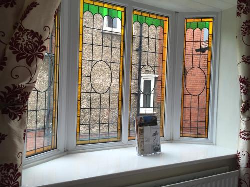 a window with four stained glass windows in a room at Chester House Guest House in Chester