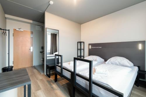 a bedroom with two bunk beds and a table at a&o Hamburg Hammer Kirche in Hamburg