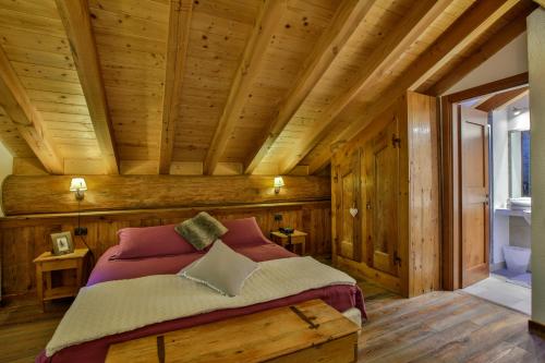 ein Schlafzimmer mit einem Bett in einem Holzhaus in der Unterkunft Ellex Eco Hotel in Gressoney-la-Trinité