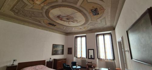 a bedroom with a ceiling with a painting on it at Albergo San Giovanni in Florence