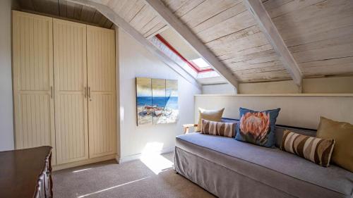 a bedroom with a couch in a room with an attic at Griki in Paternoster