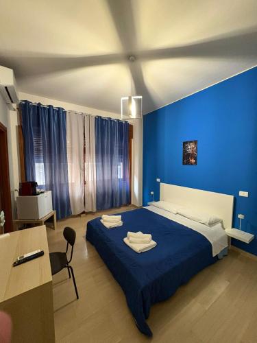 a blue bedroom with a bed and a desk at Vespro Guest House in Messina