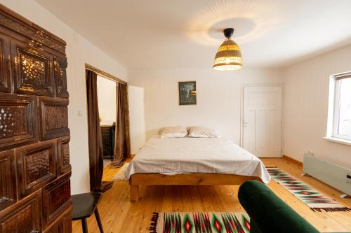 a bedroom with a bed and a couch at Menasagi Sit&Dream Cottage in Menasag-Ujfalu