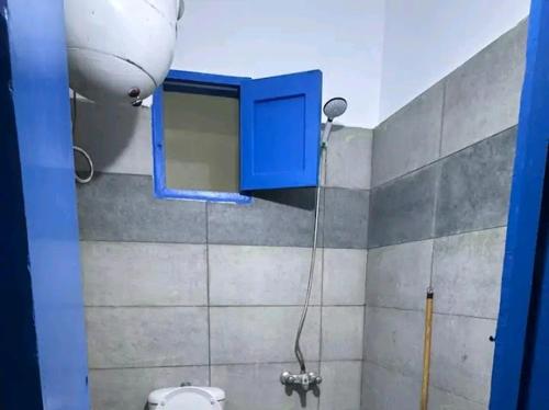a bathroom with a blue window and a toilet at Balsam hotel in Dahab