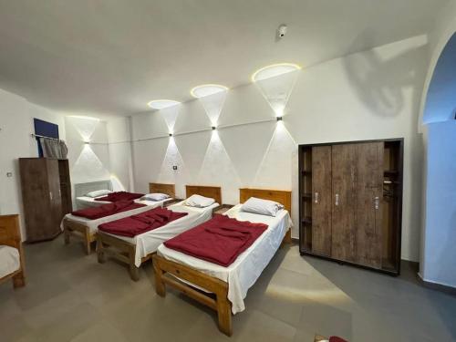 a room with four beds with red sheets at Balsam hotel in Dahab