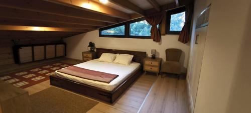 a bedroom with a bed and a desk and two windows at The Zephyr House -2- in Pyrgos