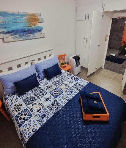 a bedroom with a bed with a blue and white bedspread at Agulhas Stay in Agulhas