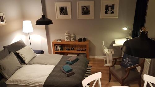 a living room with a bed and a chair at Przy Poli Negri in Bydgoszcz