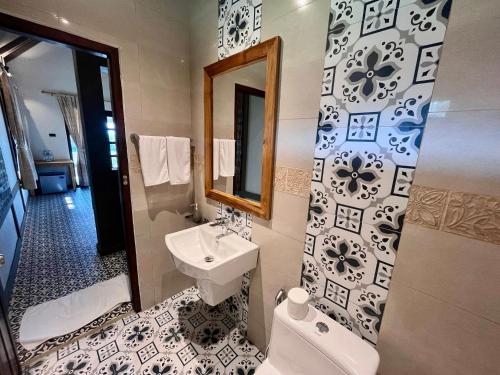 a bathroom with a sink and a toilet and a mirror at KuangSi Resort in Luang Prabang
