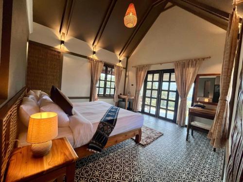 a bedroom with a bed and a tv in a room at KuangSi Resort in Luang Prabang