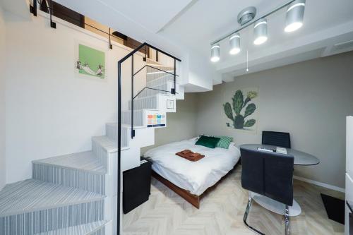 a bedroom with a bed and a desk with a laptop at Ra Grande by Tranova in Tokyo