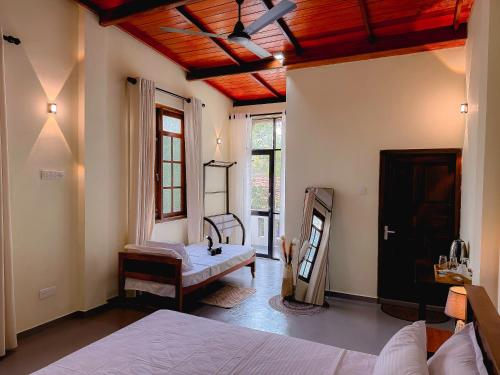 a bedroom with two beds and a wooden ceiling at Chill Tangalle in Tangalle