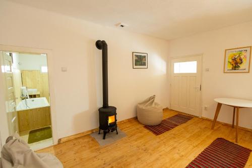 a living room with a wood stove in the corner at Menasagi Sit&Dream Cottage in Menasag-Ujfalu