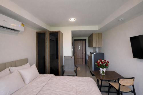 a hotel room with a bed and a table and a tableablish at MaiKhao Sunrise Sight Space in Ban Mai Salae