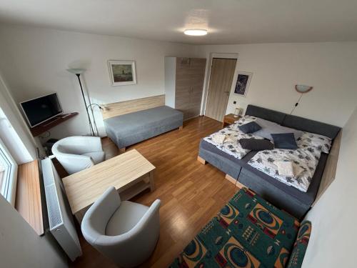 a living room with a bed and a couch at Penzion V Kolonce in Strážné