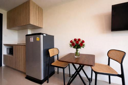 a small kitchen with a table and a refrigerator at MaiKhao Sunrise Sight Space in Ban Mai Salae