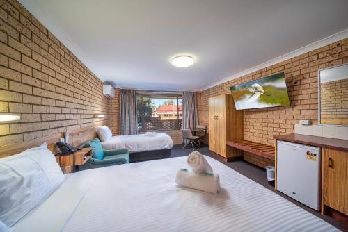 a hotel room with two beds and a tv at Cambridge Motel in Mitchell