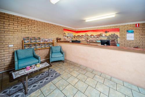 a waiting room with two blue chairs and a counter at Cambridge Motel in Mitchell
