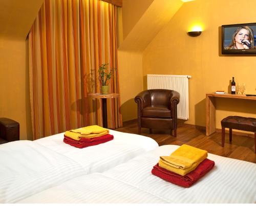 a hotel room with a bed with towels on it at Country Lodge Hotel Moriaanshoofd in Oudenaarde