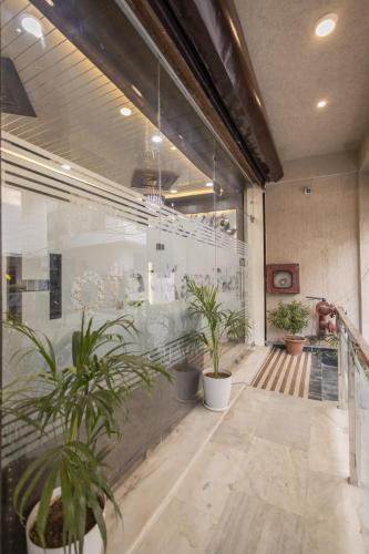 a hallway with potted plants in a building at Hotel Kamal Palace in Lucknow