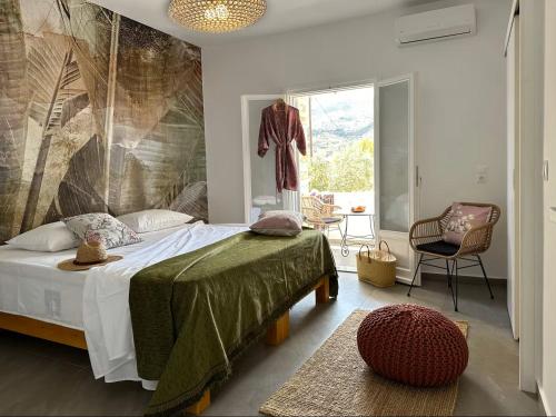 a bedroom with a bed and a large window at Olive Tree Homes in Ios Chora