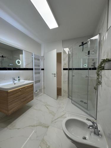 a white bathroom with a sink and a shower at Ferienwohnungen Wassergrundstück Malchow in Malchow