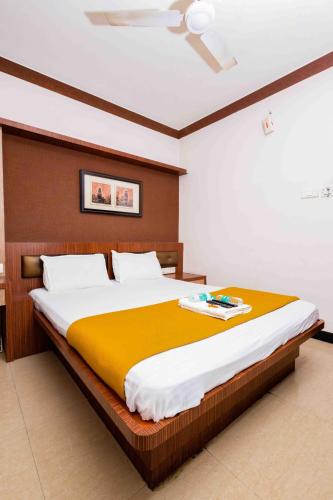 a bedroom with a large bed with a yellow blanket at Hotel DRG Heritage in Tiruppūr