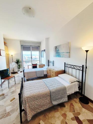 a bedroom with two beds and a living room at Cà Letizia - ApArt Seregno centralissimo in Seregno