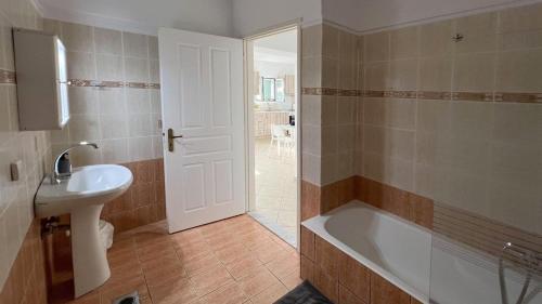 a bathroom with a bath tub and a sink at Villa Evgenia in Yénion