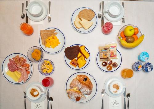 a table with plates of breakfast food on it at Hotel Sella Ronda Serenella - A 50 mt dalle piste da sci in Campitello di Fassa
