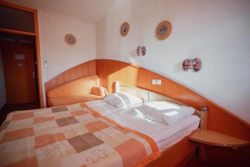 ein Schlafzimmer mit einem großen Bett mit hölzernem Kopfteil in der Unterkunft MC Hotel in Žalec
