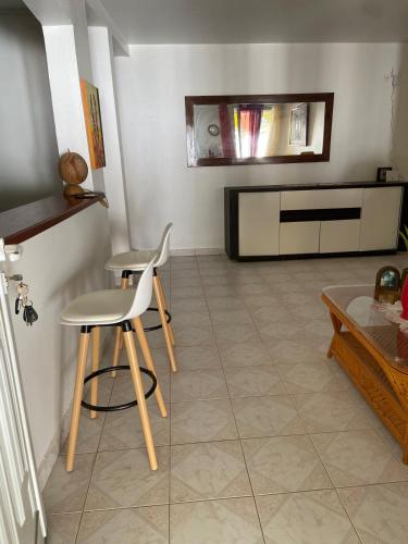 a living room with two chairs and a table at Mon petit coin de paradis in Morne-à-lʼEau