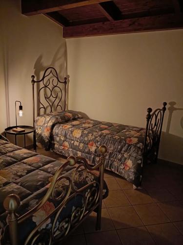 a bedroom with two beds and a table with a lamp at Ai piedi del Morrone in Tocco da Casauria