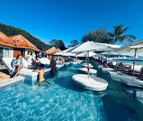 a swimming pool with people sitting on chairs and umbrellas at Exclusive Bungalow Near Swiming Pool At Kohchang Resort in Ko Chang