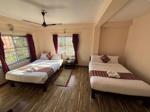 una stanza con tre letti in una stanza di Hotel crystal fall a Pokhara
