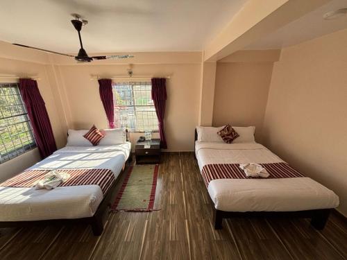 due letti in una stanza con due finestre di Hotel crystal fall a Pokhara