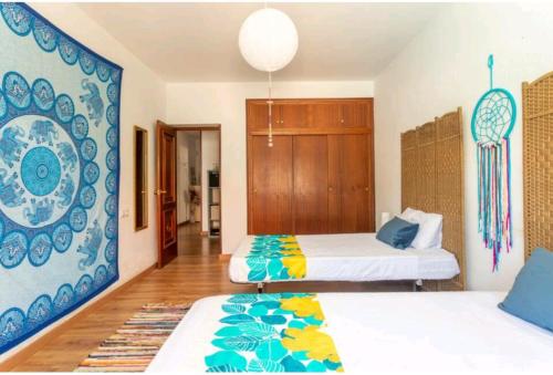a bedroom with two beds and a blue and white wall at CM Azibi Blue Room in El Campello