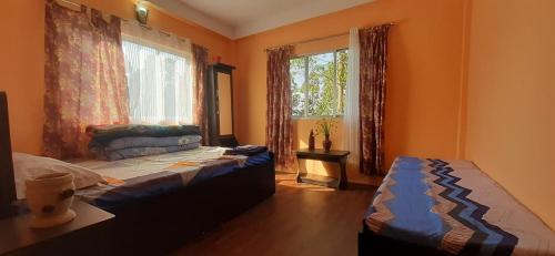a bedroom with two beds and a window at MountainBrew Homestay in Takdāh
