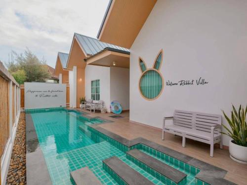 a swimming pool in the middle of a house at Rabbit Villa Bangsaray in Bang Sare