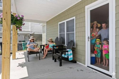 a group of people sitting on the porch of a house at Fully Renovated Steps to Beach The Americana in Hampton