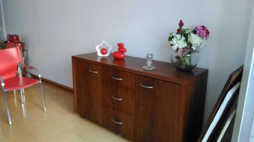 a wooden cabinet with a vase of flowers on it at Apartamento Avenida 5 de Outubro in Lisbon