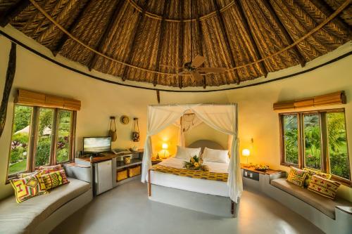 una camera con un letto in una stanza con finestre di ONE Santuario Hotel y Reserva Natural a Palomino