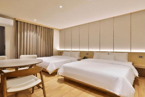 a hotel room with two beds and a table at Hotel Coolstay Gimcheon in Gimcheon