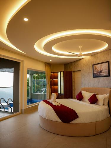 a bedroom with a large bed with a ceiling at Mount Stratus Resort Vayalada in Bālūssheri