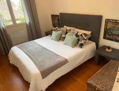 une chambre avec un grand lit blanc avec des oreillers dans l'établissement LA PHOCEENNE, à La Teste-de-Buch