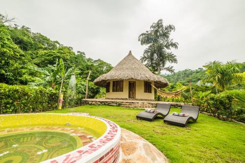 uma pequena cabana com duas espreguiçadeiras num quintal em ONE Santuario Hotel y Reserva Natural em Palomino