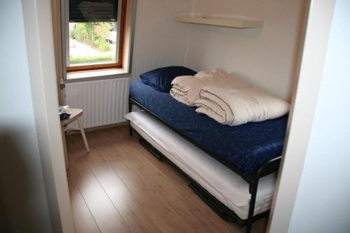 a small bed in a room with a window at Heggerank 3A in Nieuwvliet